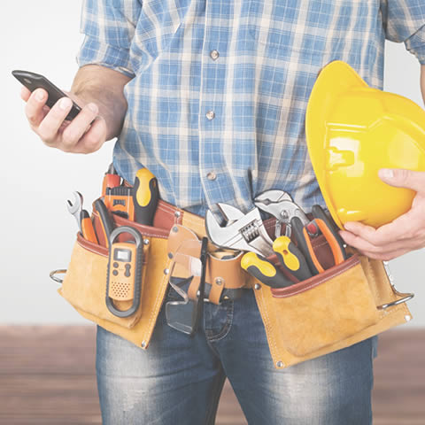 Professional electrician making a phone call with his smartphone